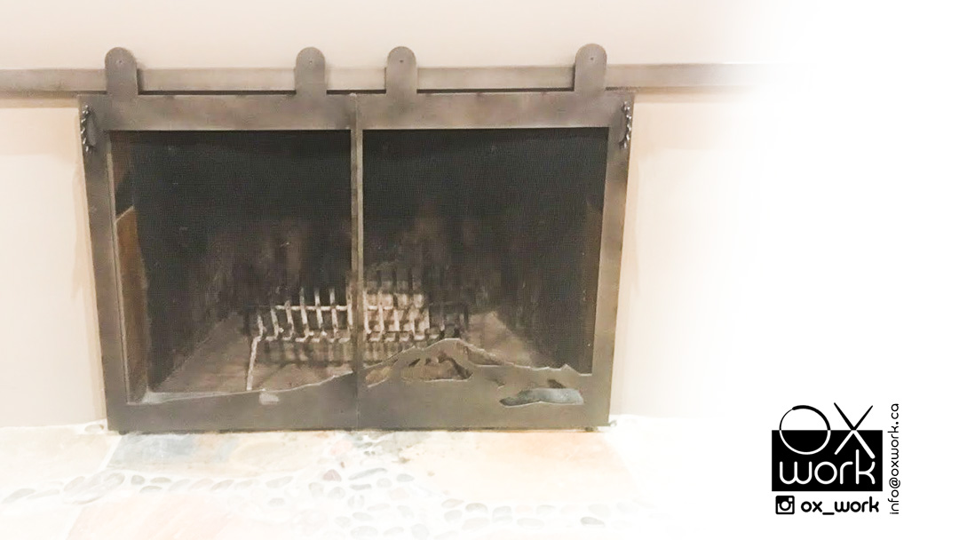 Custom fireplace cover - Mt Baker <br> Blackened steel plate cut on waterjet, steel rail on top and steel mesh